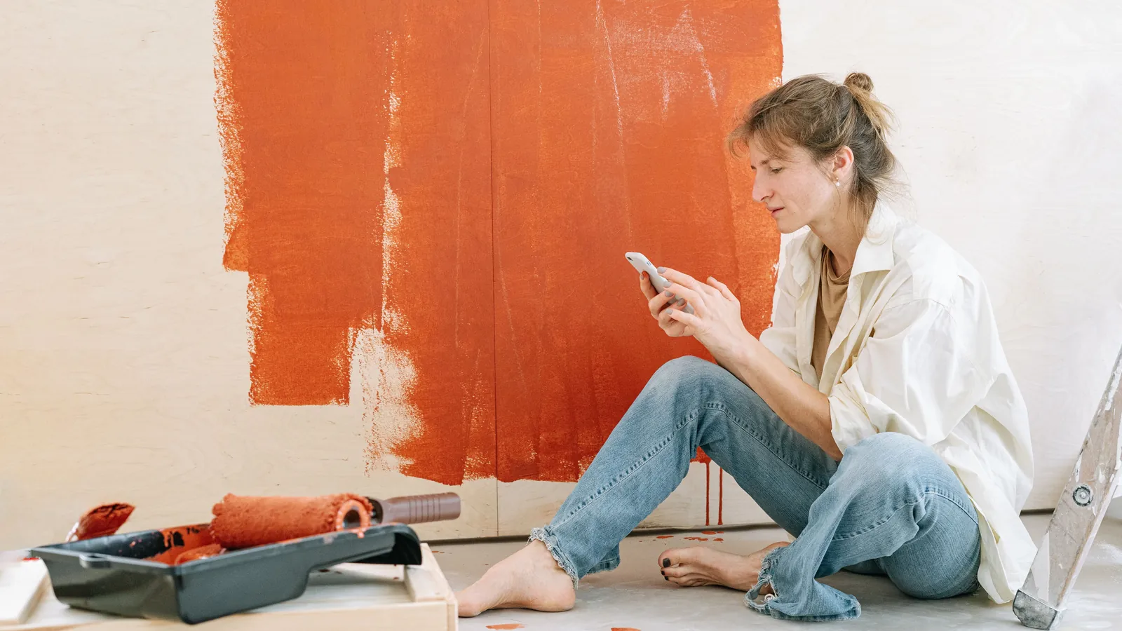 Decorator using a smartphone during a room renovation