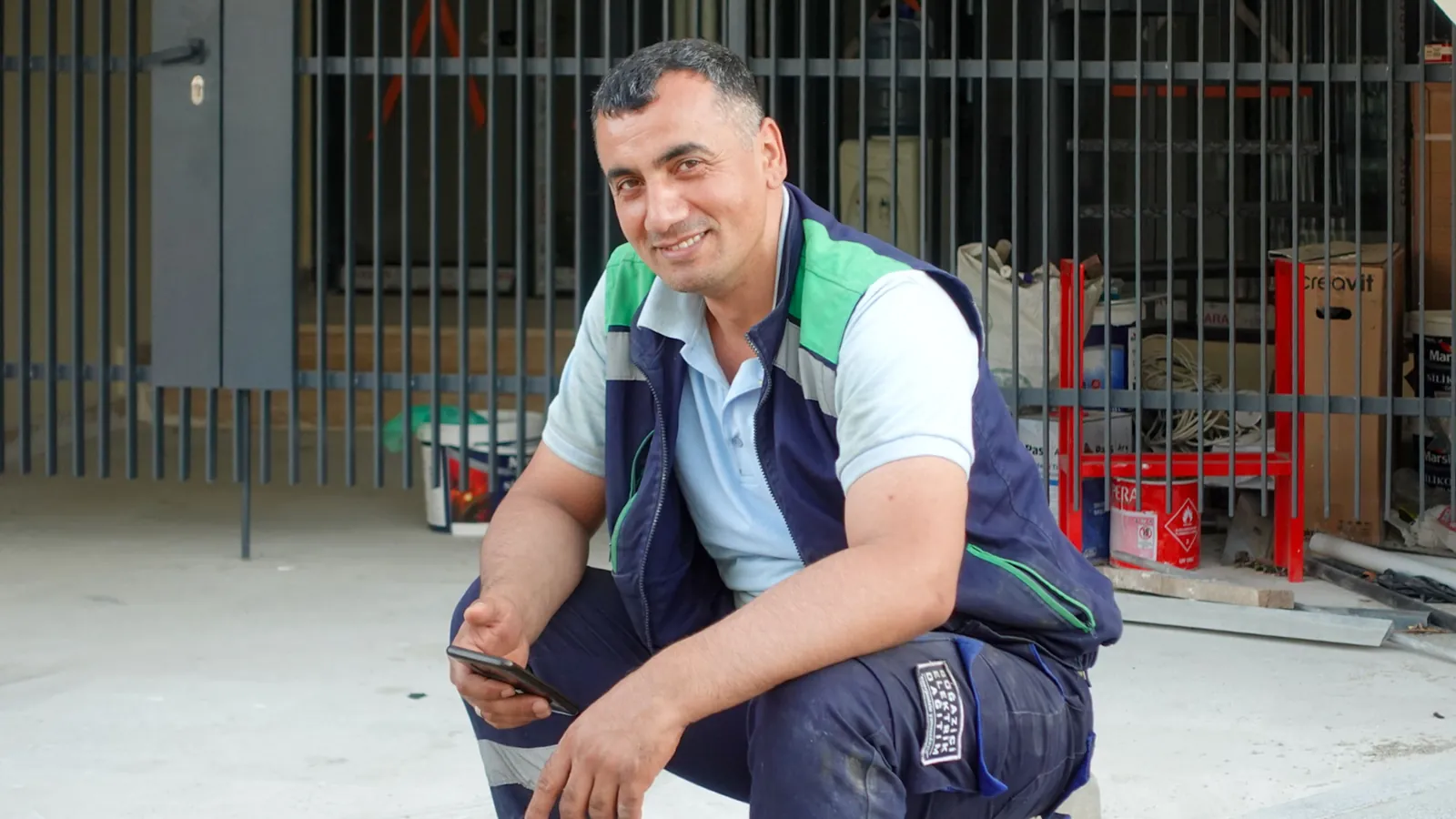 Tradesperson using a smartphone outside a job site